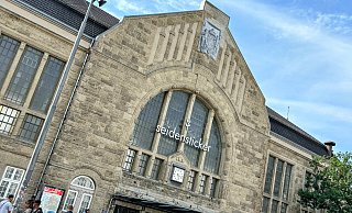 Direkt unter dem Giebel des Hauptgebäudes des Bielefelder Hauptbahnhofes thront normalerweise das Wappen des Deutschen Reiches. Aktuell ist es durch eine Plane verhüllt. - Eike J. Horstmann