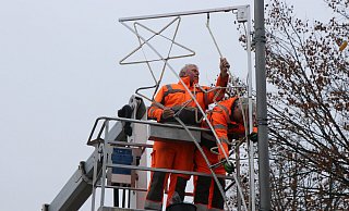 Bauhofmitarbeiter bringen vom Hubwagen aus die Weihnachtsbeleuchtung an. - Ekkehard Wind