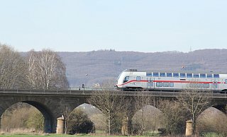 Ein Intercity fährt über die Weserflut-Eisenbahnbrücke vor der Kulisse des Wiehengebirges. Ob die Schnellzüge demnächst auf einer neuen Hochgeschwindigkeitsstrecke fahren sollen, ist derzeit Gegenstand hitziger Diskussionen. - Ulf Hanke