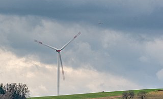 Eine Windkraftanlage dreht sich vor dunklen Wolken. Am Donnerstag wird es windig in OWL. - picture alliance/dpa