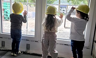 Gut behelmt lernen die Kinder ihre neue Kita „Baumhaus“ in Beverungen das erste Mal schon während der Bauphase kennen. - Projekt Begegnung Kita Baumhaus Beverungen