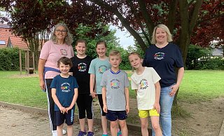 Schulleiterin Annegret Holz (v.l.), Juna, Finja, Lenja, Joshua, Julius und Konrektorin Astrid Weigmann präsentieren ihre neuen Schul-T-Shirts. - Grundschule Belke-Steinbeck/Besenkamp