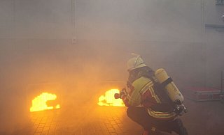 Wenn Rauch aus einer Nebelmaschine dazu kommt, wirken die digitalen Flammen realistisch. Der Feuerwehrmann zielt mit einem Laser auf das den Bildschirm. - Jobst Lüdeking
