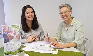 Sarah Austermühl (l.) und Meike Becker besprechen mit einem Plan der neuen Kita in Beverungen Details der Innenraumgestaltung. - Projekt Begegnung Kita Baumhaus Beverungen