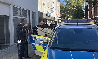 Polizisten haben dem jungen Mann Handschellen angelegt und überprüfen gerade deren Sitz. - Jobst Lüdeking