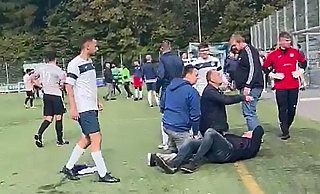 Der Screenshot eines Handy-Videos zeigt den am Boden liegenden Braker Fußball-Abteilungsleiter Jörg Pundmann und die aufgebrachte Menge aus Spielern und Zuschauern. - Repro Grundmann