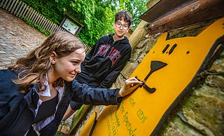 Spenden sind eine wichtige Einnahmequelle für Olderdissen: Maya und Benjamin füttern die Bärenbox, die auf dem Weg vom Haupteingang zum Bärengehege an der Bruchsteinmauer angebracht ist. - Mike-Dennis Mller / www.mdm.photo