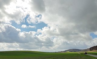 Sonne und Wolken ziehen über das Lübbecker Land. Auf den Felder am Stemweder Berg zeigt sich bereits zartes Grün. - Heike von Schulz