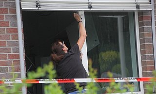 Eine Polizistin untersucht ein Fenster in der Sparkassenfiliale in Bruchmühlen. - Florian Weyand