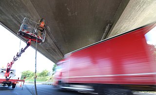 Die Reparaturarbeiten laufen in luftiger Höhe, während daneben der Verkehr fließt. - Lukas Brekenkamp