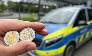 Links die Fälschung, rechts das Original: Vor dem Gebäude der Kreispolizeibehörde Gütersloh zeigt eine Polizistin die beiden Münzen zum Vergleich. Die Nachahmung erkennt man unter anderem daran, dass auf der Vorderseite Furo statt Euro steht. - Christian Bröder