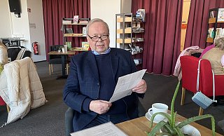 Günter Willig sitzt an einem Tisch im Alten Wartesaal. In der Hand hält er einen Flyer, der für die SPD im Kommunalwahlkampf 1975 wirbt. - Dirk Windmöller