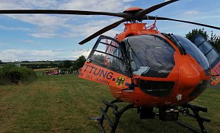 Der Rettungshubschrauber wartet darauf, den 44-Jährigen in eine Klinik fliegen zu können. Im Hintergrund ist das Unfallgeschehen zu sehen. - Burkhard Battran