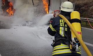 Löscharbeiten am Lkw: Das Fotos zeigt gut, wie die Akku-Teile explodieren. Die kleinen schwarzen Punkte sind offenbar Teile der E-Bikes, die weggeschleudert werden. - Feuerwehr Vlotho