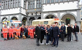 Das "Licht der Hoffnung und Menschlichkeit" halten Bürgermeister Michael Dreier (v. l.), Kreisrotkreuzleiter Thomas Gabor, Nilgün Özel, Vizepräsidentin des DRK-Landesverbandes NRW, Heinz Köhler, Präsident des DRK-Kreisverbandes Paderborn und Landrat Christoph Rüther vor dem Rathaus in der Hand, bevor es an den nächsten Kreisverband weitergereicht wird. - Pauline Maus