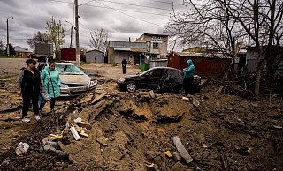 Ukraine, Mykolajiw: Zwei Frauen betrachten den Krater, den eine von Russland abgeschossene Rakete in einem Wohnviertel hinterlassen hat. - Vincenzo Circosta/dpa