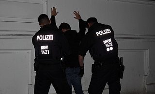 Zwei Polizeibeamte durchsuchen an der Bielefelder "Tüte" eine Person bei der nächtlichen Sonderaktion gegen Gewaltkriminalität. - Paul Brinkmann