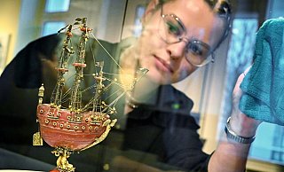 Museumspraktikantin Daria Rebriyev bewundert das einzigartige Bernsteinschiffchen in seiner beleuchteten Vitrine. - Barbara Franke