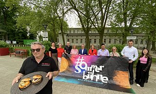 Andreas Hübner, BBQ-er aus Herford, wird mit seinem Burgerwagen ein Neuzugang beim Schlemmer-Abendmarkt sein. Im Hintergrund haben sich viele Akteure der Sommerbühne aufgereiht. - Nicole Sielermann