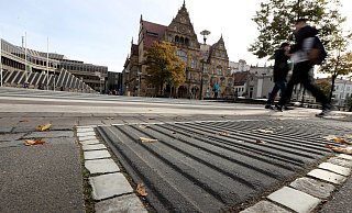 Überall in der Stadt sind auffällige Pflastersteine - wie diese anthrazitfarbenen mit breiten Rippen vor dem Alten Rathaus - verlegt. Doch was dem einen hilft, stört andere. - Wolfgang Rudolf