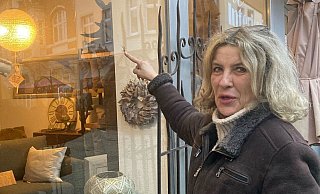 Brigitte Schäffer zeigt mit dem Finger auf das Einschussloch in ihrem Schaufenster. - Jobst Lüdeking