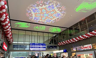Zur Eröffnung des neuen Bahnhofsgebäude strahlt bunte Lichtkunst für die Besucher an der Decke der Eingangshalle. - Jennifer Retslav