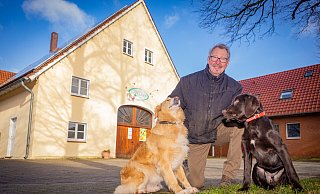 Theodor Weyand, hier mit den beiden Hofhunden, Golden-Retriever-Mix Lisa (9) und Labrador-Mischling Kally (vier Monate), bewirtschaftet einen Apfelhof mit Hühnerhaltung in Ummeln. Ein Hofladen gehört auch dazu. - Mike-Dennis Müller / www.mdm.photo