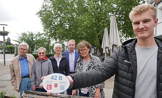 Niklas Bauer (vorne) vom Bad Lippspringer Bauamt präsentiert exemplarisch ein Notfall-Hinweisschild, das sich künftig an allen Sitzbänken im Stadtgebiet befinden soll. Bürgermeister Ulrich Lange sowie Karin Grieser, die Vorsitzende des Seniorenbeirates (2.v.l.) ihr Vorgänger Detlev Seidel (l.) und weitere Beiratsmitglieder freuen sich über die Aktion. - Klaus Karenfeld