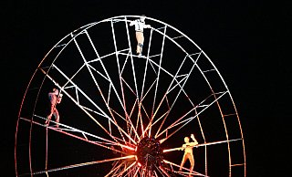 Die Akrobatinnen und Akrobaten zeigen auf dem Riesenrad ihr Können. Sie scheuen sich dabei auch nicht, komplett in den See unter ihnen abzutauchen. - Thomas Kube