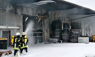Mit Schaum decken die Einsatzkräfte das Brandgut in der ausgebrannten Halle ab. - RalphMeyer