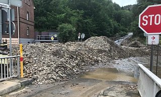 Eine Bundesstraße in Werdohl ist komplett unter Geröllmassen vergraben. Daneben sucht sich das Wasser seinen Weg. - Feuerwehr Löhne