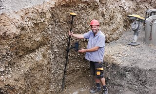 LGS-Archäologe Ralf Mahytka vermisst die Fundstelle mit dem GPS-Rover. Die Mauerreste sind inzwischen abgebrochen, die gerundete Form, die immer noch als Abdruck erkennbar ist, deutet auf einen Brunnen hin. - Sonja Vollmer