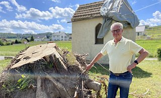 Ovenhausens Ortsausschussvorsitzender Günther Ludwig steht neben einem Baum, den der Tornado zerstört hat - ebenso wie Teile des Dachs der Kapelle. - Ralf T. Mischer