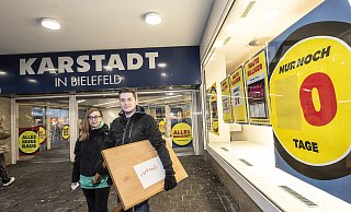 Finja-Melina Bühler (l.) und Dennis Müller sichern sich noch einen Karstadt-Tisch. Die gesamte Ladeneinrichtung steht zum Verkauf. - © Jörg Dieckmann - www. dieckmann-fotodesign.de