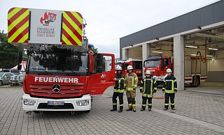 Neben der neuen Fahrzeughalle kann auch die neue Drehleiter beim Löschzug Büren besichtigt werden. Dazu laden (v. l.) Timo Kleine, Ralf Hartmann, Evelin Fink und David Elias Daniel ein. - Johannes Büttner