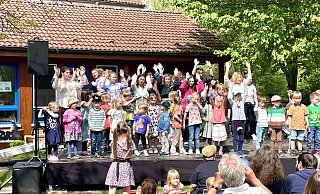 Auf der Bühne startet das Aktionsprogramm mit der Hymne des Kinderhauses. - Carola Drabon