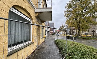 Aus der Lange Torstraße kommend, befindet sich das alte Gasthaus Hunold in prominenter Lage in der Nachbarschaft von Kirche, Supermarkt und Marktplatz. Vom Gitter eingesperrt ist neben dem Pflaster des Gehwegs auch der Briefkasten der Post. - Hans-Hermann Igges