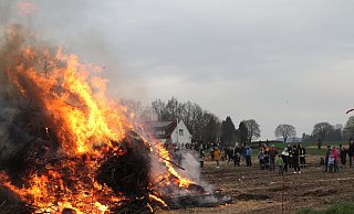 Das große Osterfeuer in Bröderhausen wird mit den Fackeln angezündet. Viele Besucher bestaunten in gebührendem Anstand den lichterloh brennenden Holzstapel. - Klaus Frensing