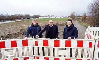 Rot-weiße Warnbaken sind aufgestellt: KER-Geschäftsführer Andreas Dornhöfer (v.l.), Bürgermeister Siegfried Lux und Geschäftsbereichsleiter Daniel Scholz vor dem Grundstück an der Osnabrücker Straße, auf dem bald Erschließungsarbeiten starten. - Gemeinde Rödinghausen