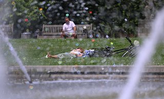 Eine Frau genießt eine Pause im Park. - David Young