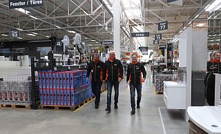 Volker Schneider (Vertriebsleiter Region Nord), Alexander Ulbrich (Marktleiter in Löhne) und Gerald Neumayr (Geschäftsführer Vertrieb) gehen gemeinsam den breiten Mittelgang entlang. - Judith Gladow