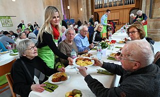 Melek Yapar reicht Walter Droß einen Schnitzel-Teller. Gegenüber sitzt seine Ehefrau Gerda Groß. - Barbara Franke