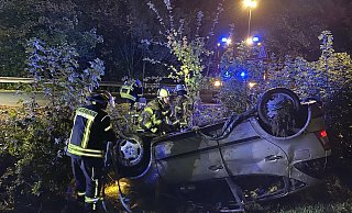Einsatzkräfte der Feuerwehr sichern den verunglückten Pkw, der im Böschungsbereich liegen geblieben ist. - Feuerwehr Altenbeken