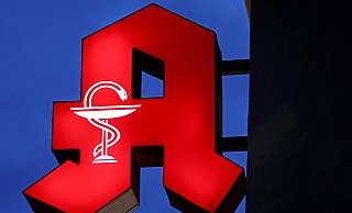 Das Apotheken-Logo leuchtet an einer Apotheke. - Oliver Berg/dpa