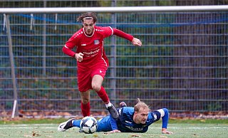 Rot obenauf, Blau am Boden: Während Levin Güzelel von der SG FA Herringhausen-Eickum mit dem Ball davonstürmt, liegt SCH-Kapitän Nico Bartling bäuchlings auf dem Kunstrasen. - Yvonne Gottschlich