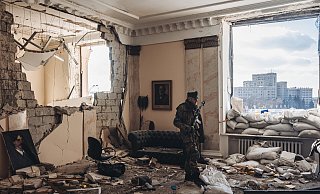 Ein ukrainischer Soldat vor dem zerstörten Regierungsgebäude in Charkiw. - picture alliance / AA