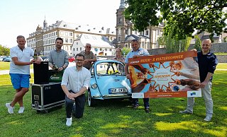 Martin Stich (Bock auf Büren,v.l.), David Haupt (DJ), Fabian Wälter (Westenergie), Karl Glahe (Oldtimerfreunde, mit dem Heinkel Trojan), Marianne Witt-Stuhr (Stadtmarketing), Daniel Engels (Ausschussvorsitzender) und Stefan Friedrich (OWL-Booking) freuen sich auf den Musik- und Kultursommer in Büren. - Stadt Büren