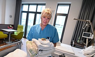 Wie im Hotel: Pflegekraft Andrea Schindel in einem der 13 großzügigen Patientenzimmer mit Balkon, Sitzecke, Minibar, kostenlosem Wäscheservice und weiteren Annehmlichkeiten. - Barbara Franke