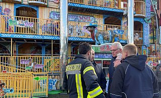 Feuerwehr und Polizei stehen vor einem Laufgeschäft: Ein Mann ist auf der Pollhans-Kirmes (Kreis Gütersloh) aus einem Laufgeschäft gestürzt und gestorben. - Christian Müller/Westfalennews/dpa