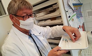 Allgemeinmediziner Rupert Lessman holt die aufgezogenen Spritzen aus dem Kühlschrank. - Dieter Scholz